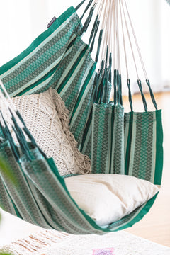 Cumbia Organic Agave hammock chair with a cushion, hanging against a white background