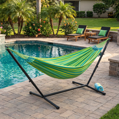 Green and yellow LA SIESTA Brisa Lime hammock on a black Nautico stand beside a pool